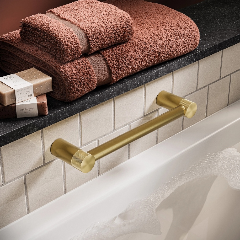 Lifestyle image of the hib. Zepto Brushed Brass Grab Bar mounted above a bathtub